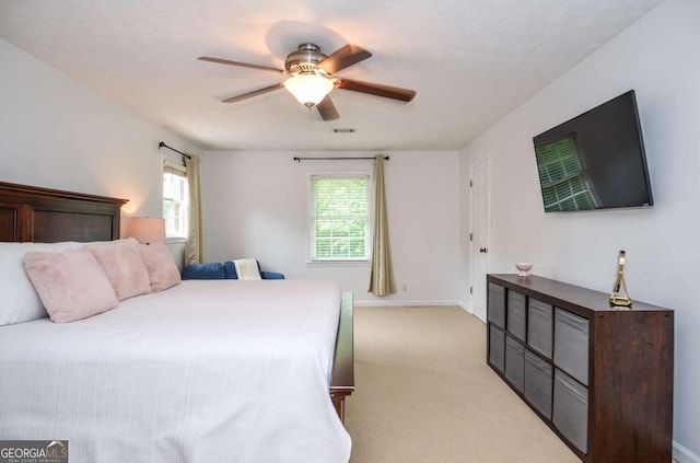 bedroom with light colored carpet, ceiling fan, and baseboards