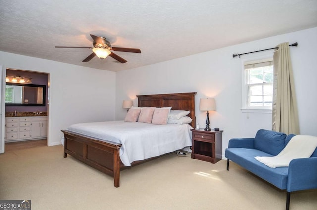 bedroom featuring light colored carpet, ensuite bath, ceiling fan, and baseboards