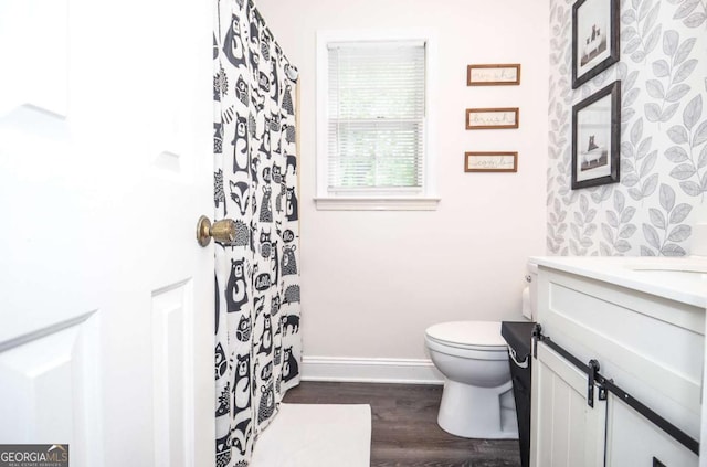 full bath with toilet, vanity, wood finished floors, baseboards, and curtained shower