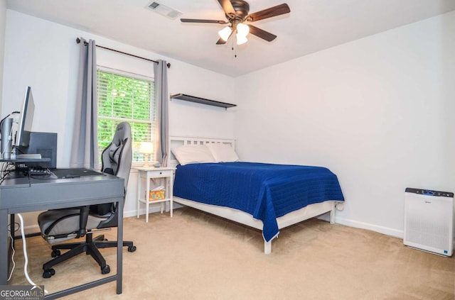 bedroom featuring light carpet, a desk, baseboards, and a ceiling fan