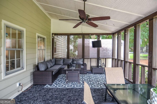 sunroom with ceiling fan, an outdoor living space, outdoor dining area, and lofted ceiling