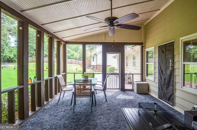 sunroom featuring outdoor dining area, a ceiling fan, lofted ceiling, and plenty of natural light