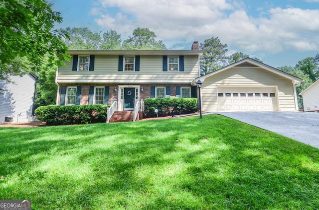 view of front of home featuring a chimney, a front yard, brick siding, and concrete driveway