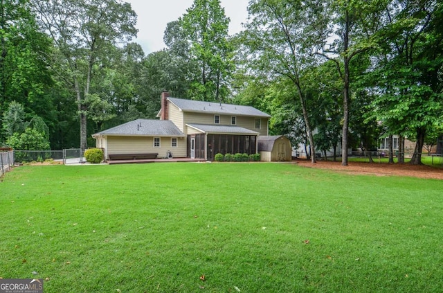back of property with a sunroom, a shed, a chimney, an outbuilding, and view of scattered trees