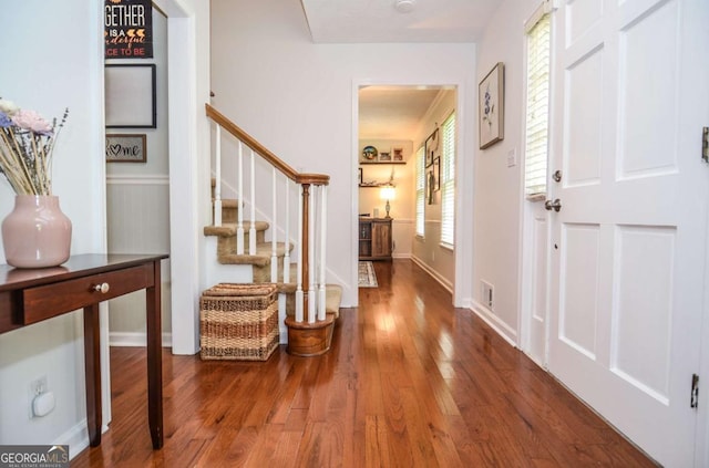 foyer entrance with wood finished floors, stairs, and baseboards
