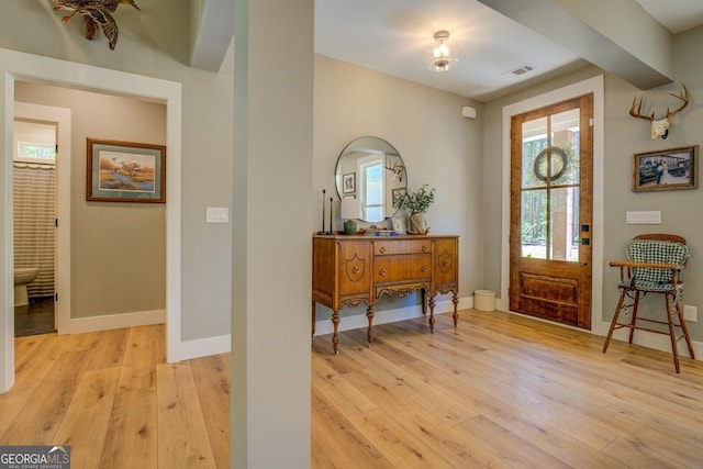 foyer entrance featuring light wood finished floors and baseboards