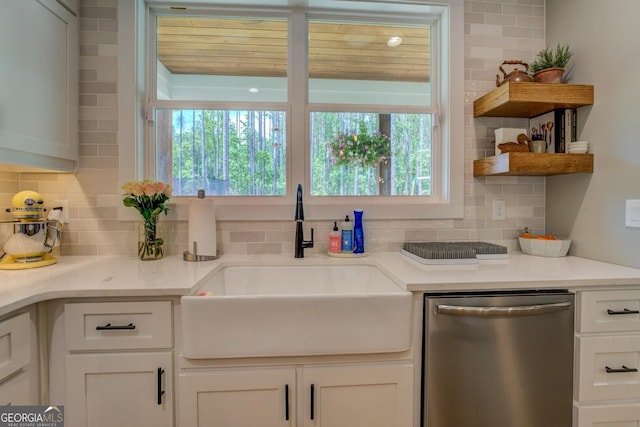 kitchen featuring dishwasher, a sink, plenty of natural light, and white cabinetry