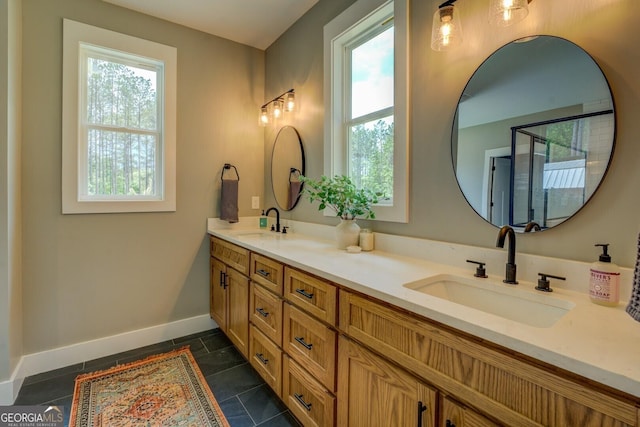 bathroom with baseboards and double vanity