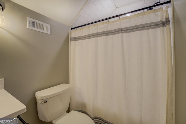 bathroom with toilet and a shower with shower curtain