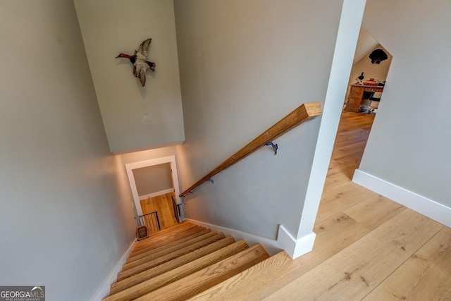 stairs with wood finished floors and baseboards
