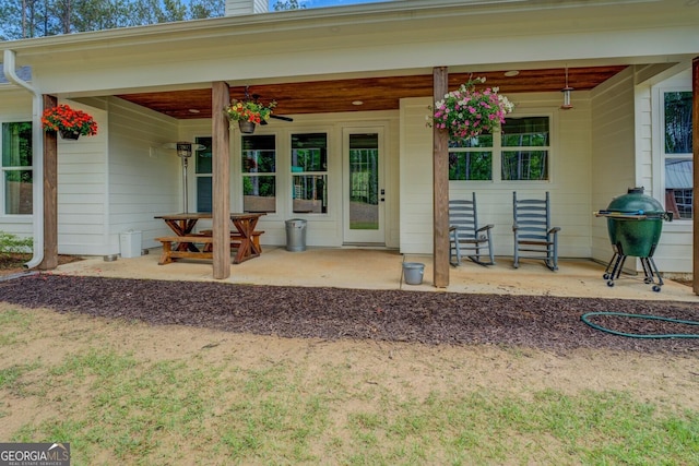 view of exterior entry featuring a chimney and covered porch