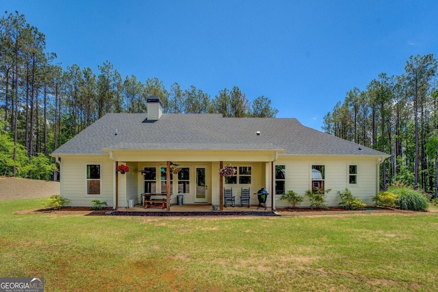 rear view of house featuring a yard, a chimney, a patio, and ceiling fan