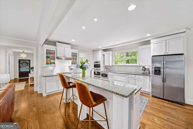 66 Mobile Ave NE, Atlanta, GA 30305 - kitchen featuring appliances with stainless steel finishes, decorative backsplash, white cabinetry, a kitchen breakfast bar, and recessed lighting