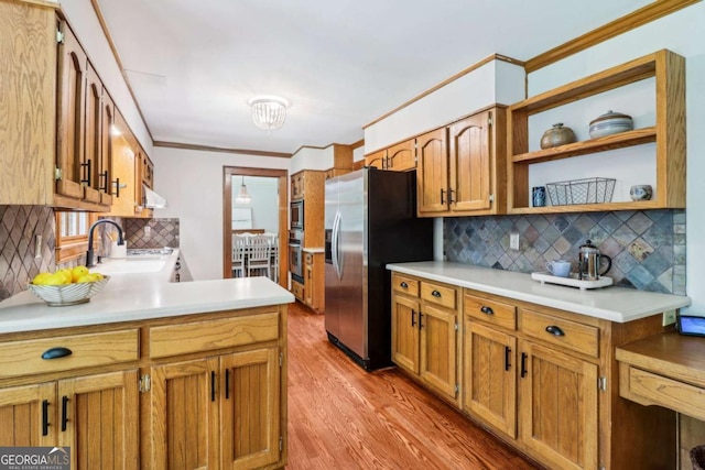 kitchen with stainless steel appliances, open shelves, decorative backsplash, a sink, and light wood-style floors