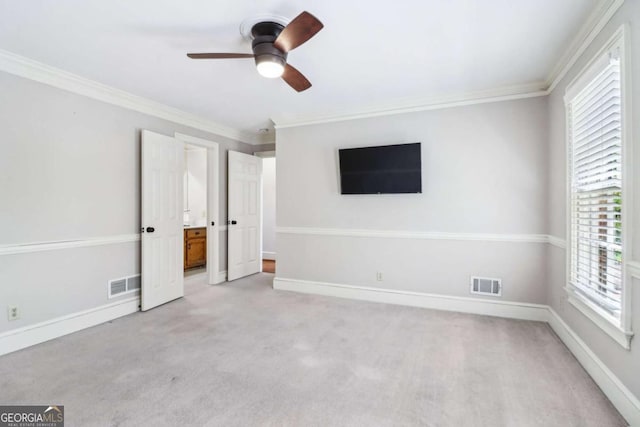 unfurnished bedroom with multiple windows, crown molding, light colored carpet, and baseboards