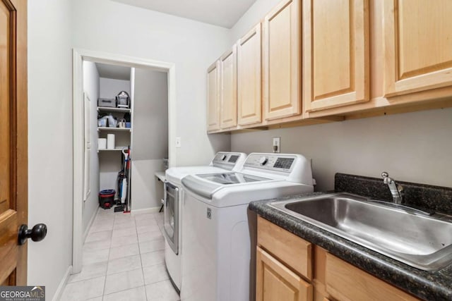 clothes washing area with independent washer and dryer, cabinet space, light tile patterned floors, and baseboards