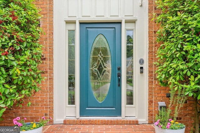 view of exterior entry with brick siding and board and batten siding