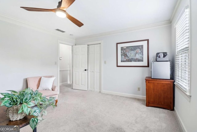 sitting room with ornamental molding, light colored carpet, ceiling fan, and baseboards