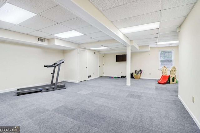 exercise room featuring a paneled ceiling, carpet floors, and baseboards