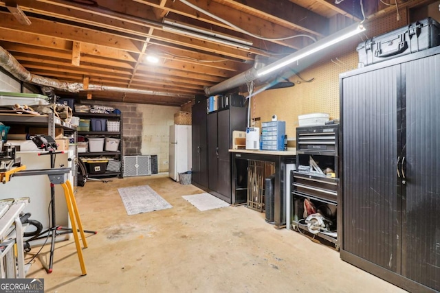unfinished basement featuring freestanding refrigerator