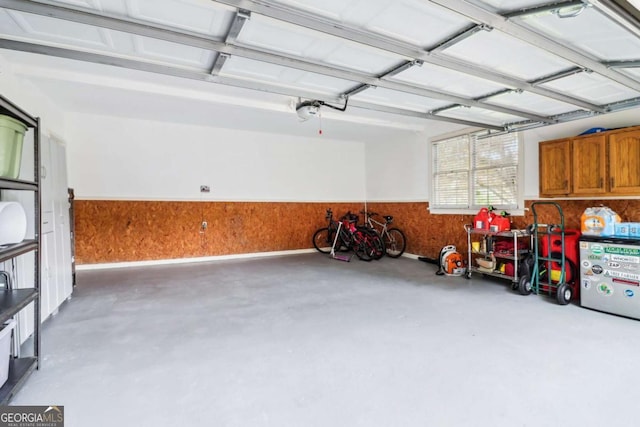 garage featuring a garage door opener and a wainscoted wall