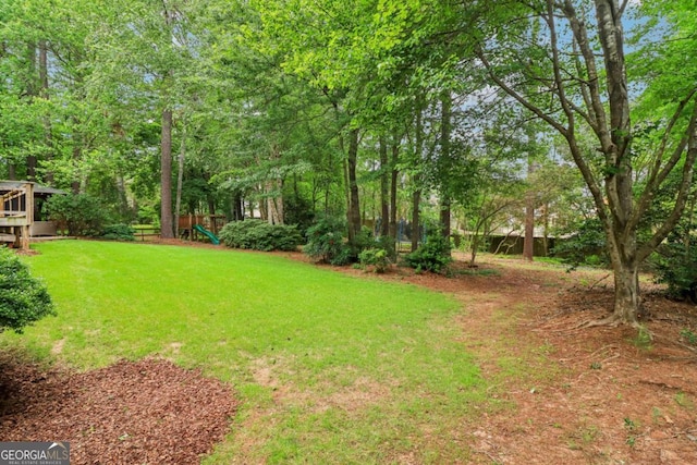 view of green lawn with a playground