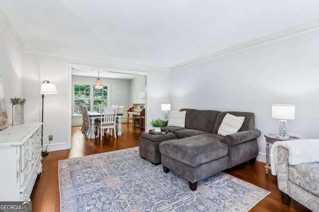 living area with ornamental molding, dark wood finished floors, and baseboards