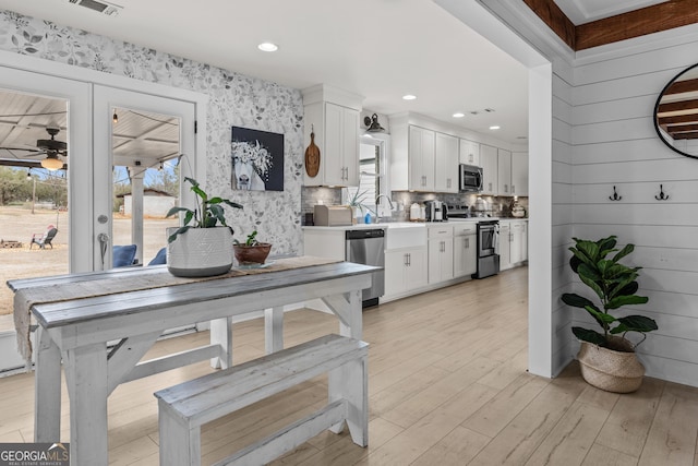 4739 Lower Jersey Rd, Oxford, GA 30054 - kitchen featuring stainless steel appliances, healthy amount of natural light, ceiling fan, white cabinets, and wallpapered walls