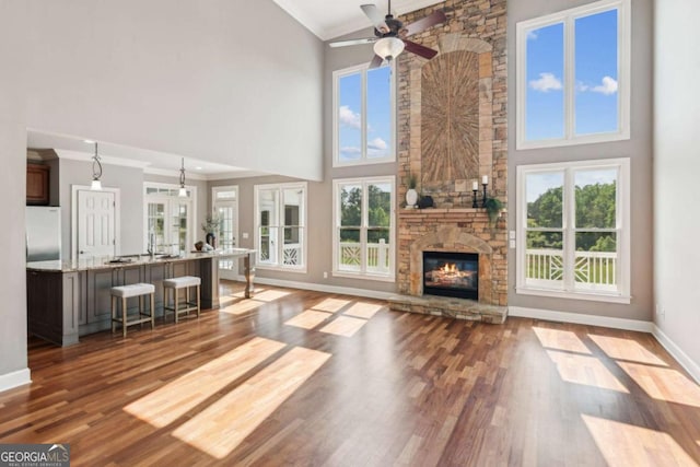 79 Gold Creek Ct, Dawsonville, GA 30534 - unfurnished living room with ornamental molding, a high ceiling, a ceiling fan, wood finished floors, and baseboards