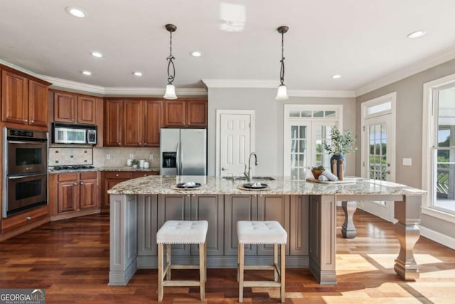 79 Gold Creek Ct, Dawsonville, GA 30534 - kitchen with stainless steel appliances, a sink, dark wood-style flooring, brown cabinets, and ornamental molding