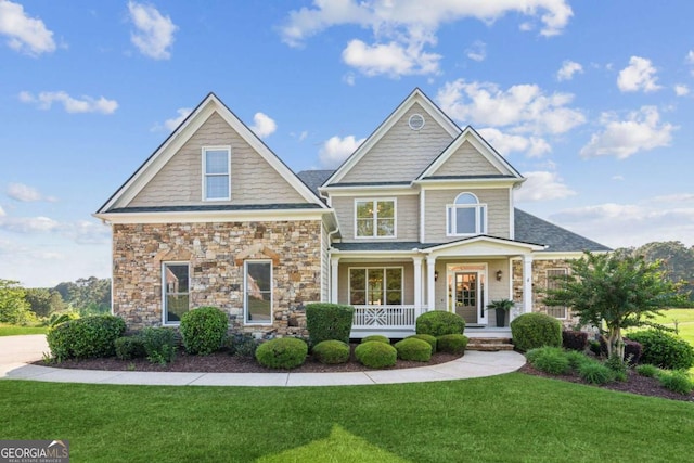79 Gold Creek Ct, Dawsonville, GA 30534 - craftsman-style home with covered porch, a front yard, and stone siding