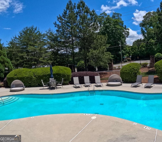 805 Pleasant Hill Rd NW Unit 343, Lilburn, GA 30047 - community pool featuring a patio, fence, and view of scattered trees