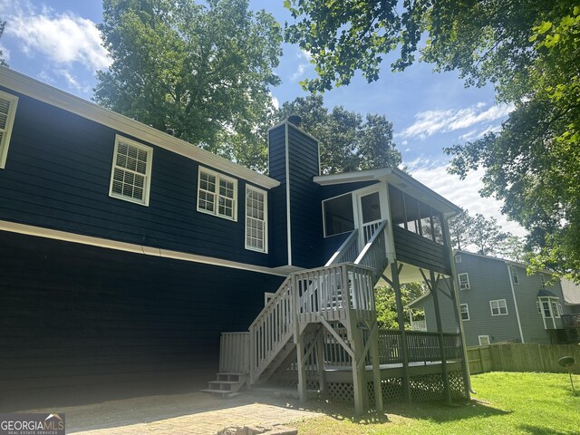 4790 Brandon Acres Ln, Buford, GA 30519 - rear view of house featuring stairway, a lawn, a chimney, a deck, and a sunroom