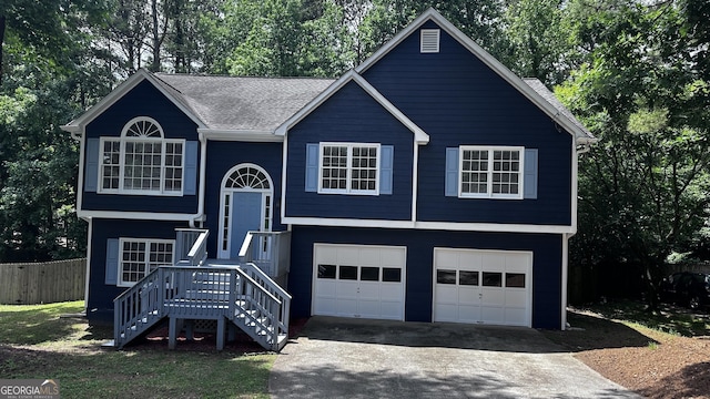 4790 Brandon Acres Ln, Buford, GA 30519 - raised ranch featuring asphalt driveway, an attached garage, fence, a shingled roof, and view of wooded area