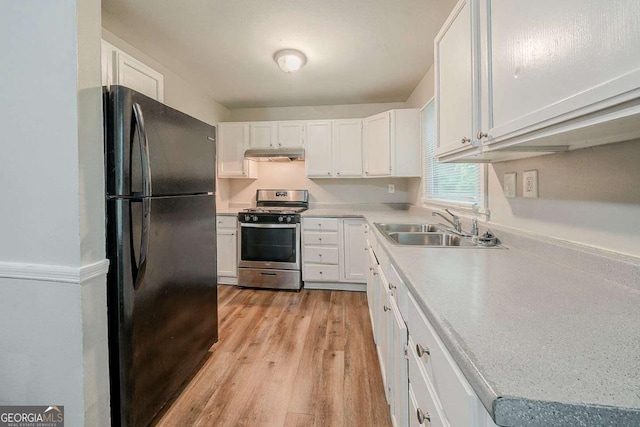 3731 Adkins Rd NW, Atlanta, GA 30331 - kitchen with freestanding refrigerator, gas stove, under cabinet range hood, a sink, and white cabinetry