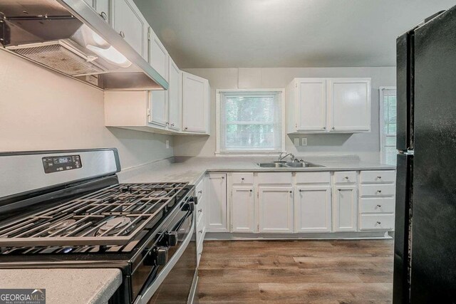 3731 Adkins Rd NW, Atlanta, GA 30331 - kitchen with gas range, freestanding refrigerator, under cabinet range hood, and white cabinetry