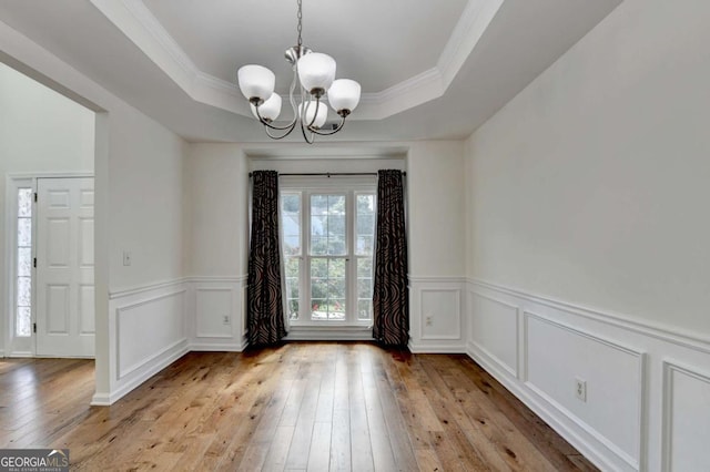 1095 S Bethany Creek Dr, Alpharetta, GA 30004 - unfurnished dining area featuring a chandelier, light wood finished floors, a tray ceiling, wainscoting, and a decorative wall
