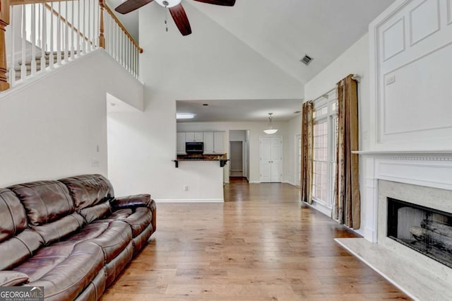 1095 S Bethany Creek Dr, Alpharetta, GA 30004 - living area featuring ceiling fan, light wood-type flooring, a fireplace, high vaulted ceiling, and baseboards