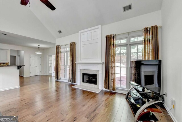1095 S Bethany Creek Dr, Alpharetta, GA 30004 - living room with a fireplace with raised hearth, a ceiling fan, wood finished floors, high vaulted ceiling, and baseboards