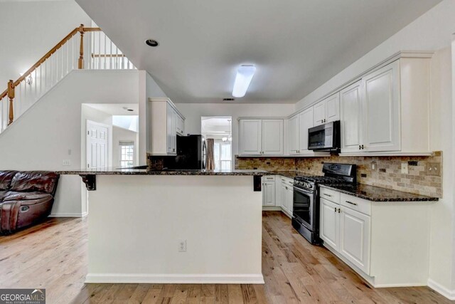 1095 S Bethany Creek Dr, Alpharetta, GA 30004 - kitchen with gas range, dark stone countertops, white cabinetry, and tasteful backsplash