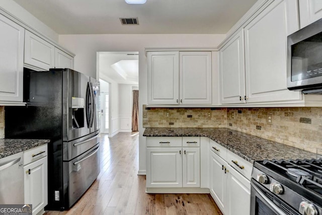 1095 S Bethany Creek Dr, Alpharetta, GA 30004 - kitchen featuring appliances with stainless steel finishes, white cabinetry, light wood finished floors, and backsplash