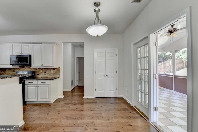 1095 S Bethany Creek Dr, Alpharetta, GA 30004 - kitchen featuring stainless steel microwave, white cabinets, range with gas stovetop, tasteful backsplash, and pendant lighting