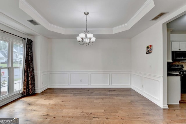 1095 S Bethany Creek Dr, Alpharetta, GA 30004 - unfurnished dining area with a tray ceiling, a chandelier, light wood-style floors, wainscoting, and crown molding