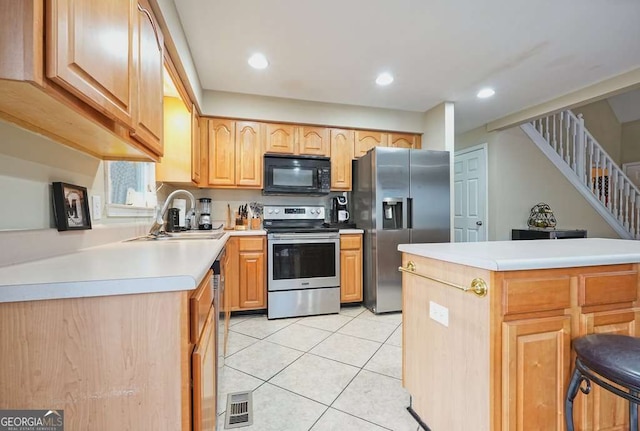 kitchen with stainless steel appliances, a sink, light tile patterned floors, light countertops, and recessed lighting