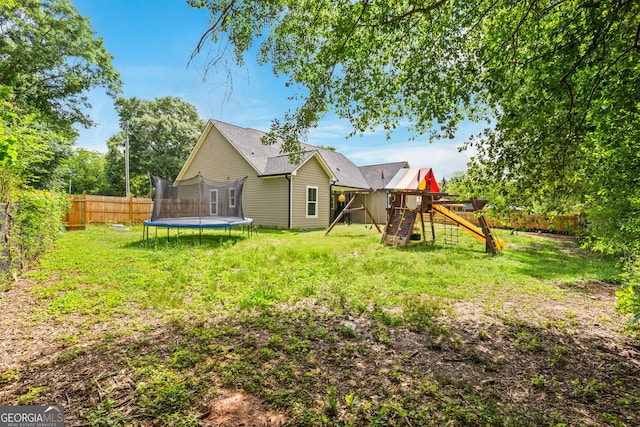 view of yard with a trampoline and a playground