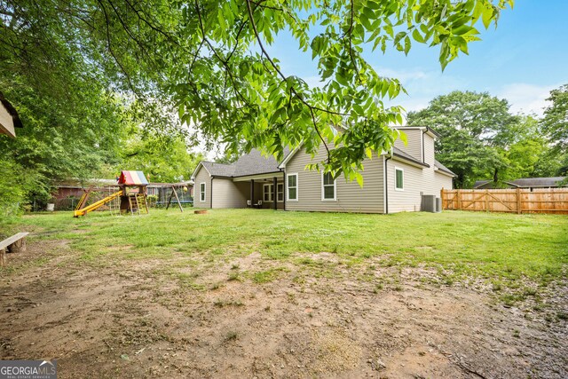back of property with a playground and cooling unit