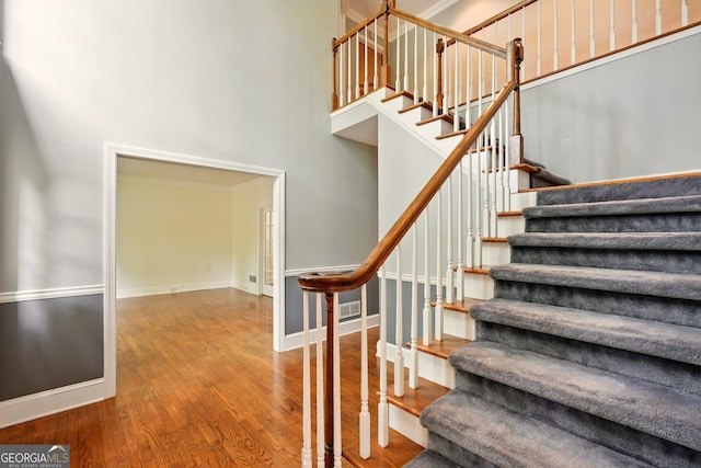 1256 Spring Park Dr SW, Atlanta, GA 30311 - staircase with wood finished floors, a towering ceiling, and baseboards