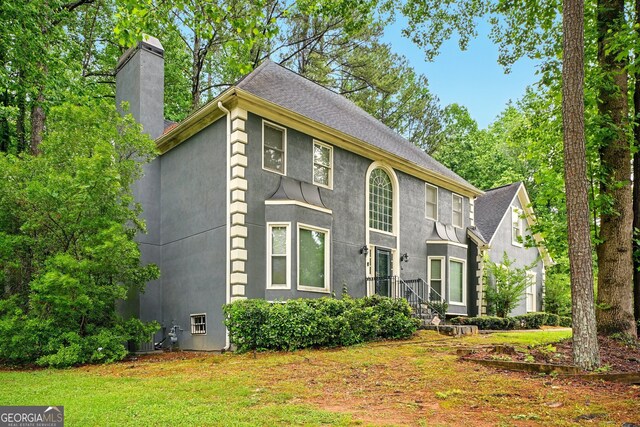 1256 Spring Park Dr SW, Atlanta, GA 30311 - view of front of home featuring stucco siding, a chimney, a front lawn, and a shingled roof