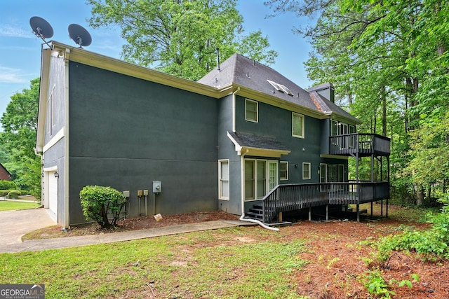 1256 Spring Park Dr SW, Atlanta, GA 30311 - back of property with a wooden deck, an attached garage, stucco siding, roof with shingles, and driveway