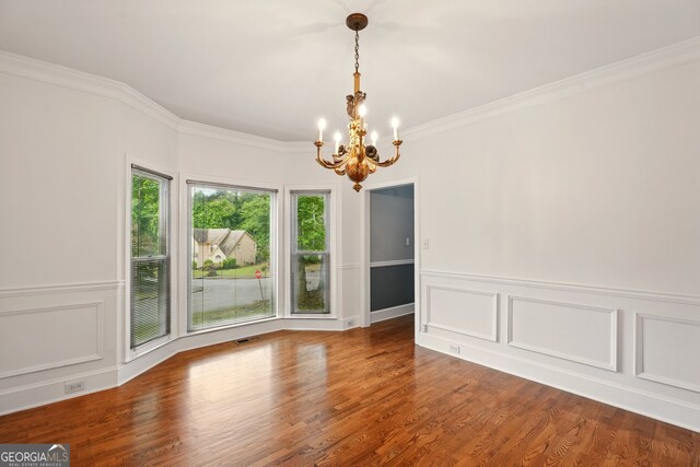 1256 Spring Park Dr SW, Atlanta, GA 30311 - unfurnished dining area featuring a chandelier, ornamental molding, wood finished floors, a decorative wall, and a wainscoted wall